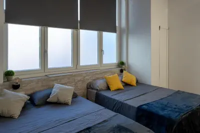two beds with yellow pillows in a room with windows at Alojamiento, hospedaje para 6 personas in Valencia