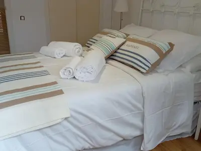a white bed with towels and pillows on it at Casa El Azud La Cañada 1 minuto metro in Partida de La Cañada