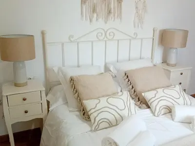 a bedroom with a bed with white sheets and pillows at Casa El Azud La Cañada 1 minuto metro in Partida de La Cañada