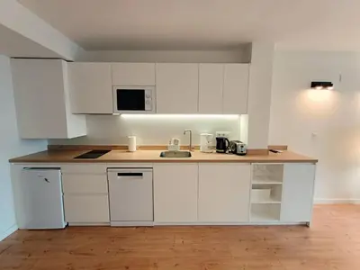a kitchen with white cabinets and a counter top at LOFT ROYAL - apartamento 