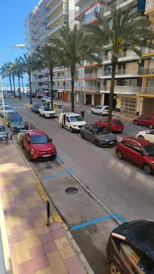 a parking lot with parked cars and palm trees at Medusa Felix in Cullera