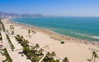 a beach with a large group of people on it at Medusa Felix in Cullera