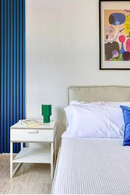 a bedroom with a white bed and a nightstand with a lamp at Private Garden Villa near Valencia with Cinema and Gym in La Eliana
