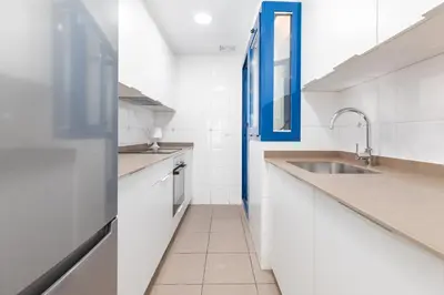 a kitchen with white counters and a sink at ApartUP Patacona Iconic II in Valencia