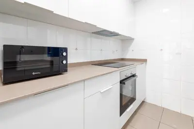 a kitchen with a microwave and a stove at ApartUP Patacona Iconic II in Valencia