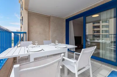 a white dining table and chairs on a balcony at ApartUP Patacona Iconic II in Valencia