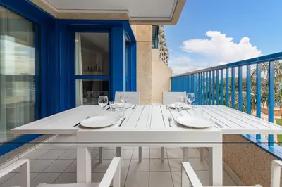 a white dining table on the balcony of a house at ApartUP Patacona Iconic II in Valencia