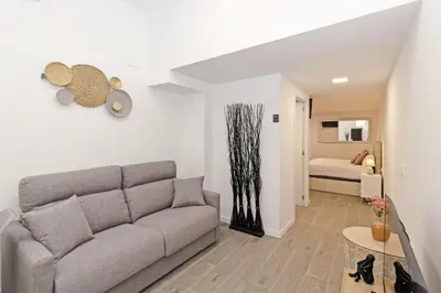 a living room with a couch and a bedroom at GuestReady - Llovera apartments in Valencia