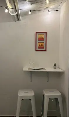 two white stools sitting under a shelf on a wall at Mi refugio en la playa in Moncófar