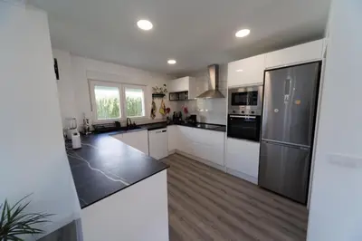 a kitchen with white cabinets and black appliances at Luxury villa 20 minutes from Valencia in Lliria