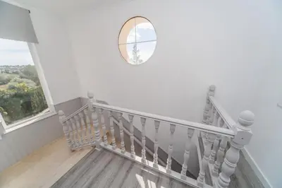 a white staircase with a round mirror on the wall at Luxury villa 20 minutes from Valencia in Lliria