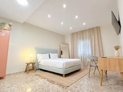 a bedroom with a bed and a table and a desk at Beach Room Valencia, NETFLIX, 4 mins walk to the beach in Valencia