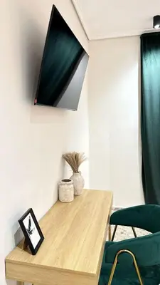 a room with a wooden table and a green chair at Beach Room Valencia, NETFLIX, 4 mins walk to the beach in Valencia