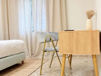 a bedroom with a chair and a wooden table at Beach Room Valencia, NETFLIX, 4 mins walk to the beach in Valencia