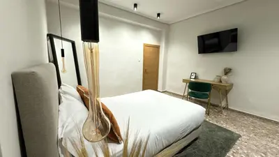 a bedroom with a bed and a desk and a television at Beach Room Valencia, NETFLIX, 4 mins walk to the beach in Valencia