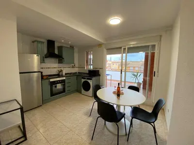 a kitchen with a table and chairs and a kitchen with a view at Apartamento playa de chilches in Chilches