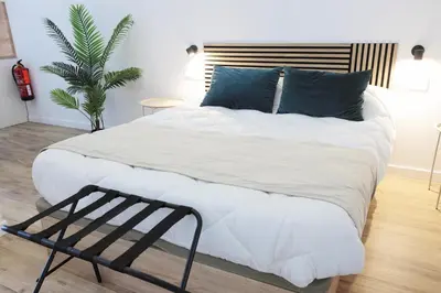 a bedroom with a large white bed with blue pillows at Total Valencia Sorolla in Valencia