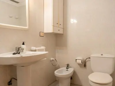 a white bathroom with a sink and a toilet at Apartamento Pinzón in Moncófar