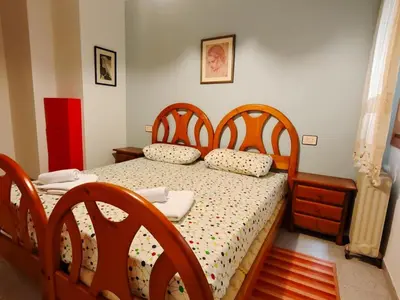 a bedroom with a bed with two wooden headboards at Apartamento Pinzón in Moncófar