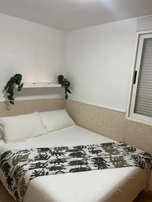 a bedroom with a bed with a black and white blanket at Playa sol y arena in Valencia