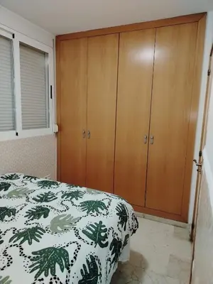 a bedroom with wooden cabinets and a bed at Playa sol y arena in Valencia