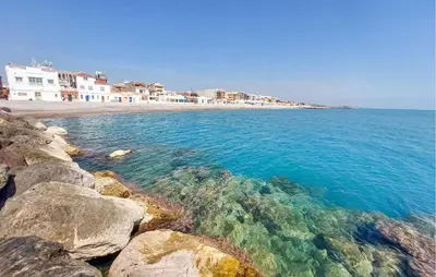 a beach with rocks and the ocean and buildings at 2 Bedroom Awesome Apartment In Moncofa in Moncófar