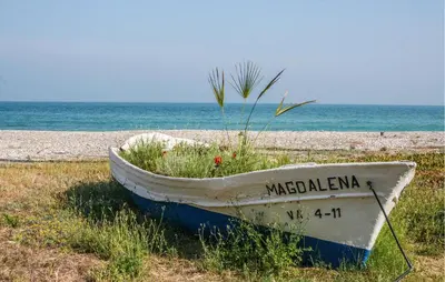 a boat sitting in the grass on the beach at 2 Bedroom Awesome Apartment In Moncofa in Moncófar