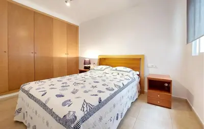 a bedroom with a bed and a wooden cabinet at 2 Bedroom Awesome Apartment In Moncofa in Moncófar