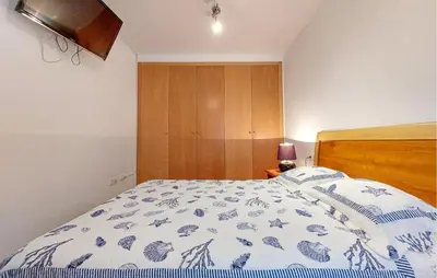 a bedroom with a bed with a blue and white comforter at 2 Bedroom Awesome Apartment In Moncofa in Moncófar