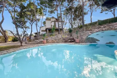 a large pool with blue water in front of a house at Villa near Valencia 17PAX, Pool, Cinema, BBQ, KidsRoom in Manises