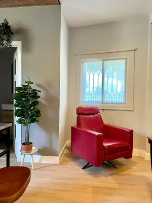a red chair in a living room with a window at Encantador apartamento boutique a 5 min del metro in Bétera