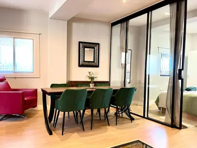 a dining room with a table and green chairs at Encantador apartamento boutique a 5 min del metro in Bétera
