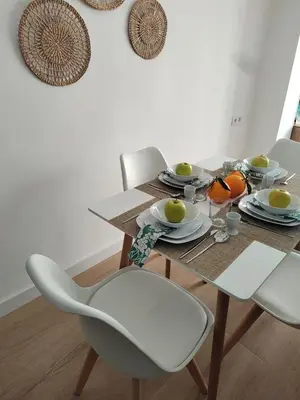a dining room table with white chairs and a wooden table with food at New central flat with AC and Wifi in Valencia
