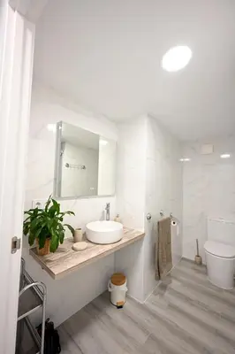 a white bathroom with a sink and a toilet at El sonido del mar in Puerto de Sagunto