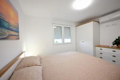 a bedroom with a bed and a dresser and a window at El sonido del mar in Puerto de Sagunto