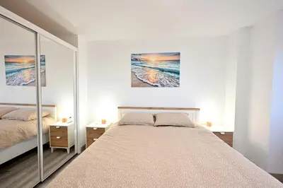 a bedroom with a bed and a painting on the wall at El sonido del mar in Puerto de Sagunto