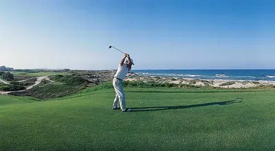 a man swinging a golf club on a golf course at Fantastic beach apartment near Valencia in Valencia
