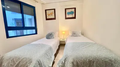 two twin beds in a room with a window at Complejo de playa in Valencia