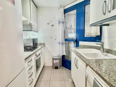 a kitchen with white cabinets and a sink at Complejo de playa in Valencia