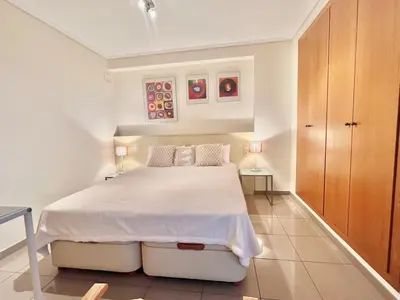 a white bedroom with a white bed and two lamps at Complejo de playa in Valencia