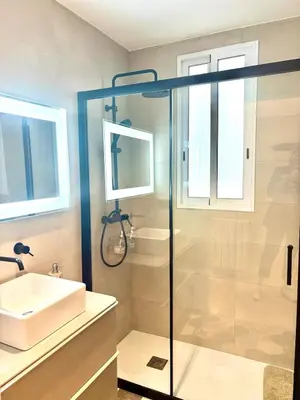a bathroom with a glass shower and a sink at Family Home Valencia in Aldaia