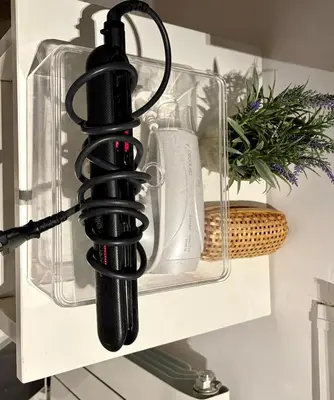 a black cord holder on a shelf with a plant at Family Home Valencia in Aldaia