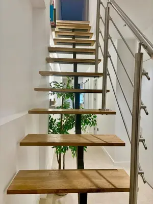 a wooden staircase with a plant in the middle at Family Home Valencia in Aldaia