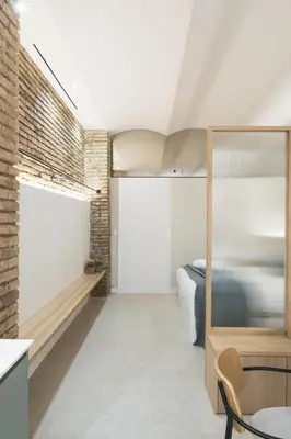 a bedroom with a bed and a brick wall at FLORIT FLATS - Estudio de Diseño en el Corazón de Ruzafa in Valencia
