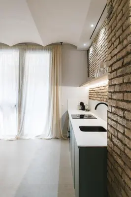 a kitchen with a sink and a brick wall at FLORIT FLATS - Estudio de Diseño en el Corazón de Ruzafa in Valencia