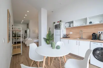 a kitchen and living room with a white table and chairs at Flats Uruguay in Valencia