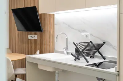 a kitchen counter with a sink with a tv above it at VLC HOST - Oriente in Valencia