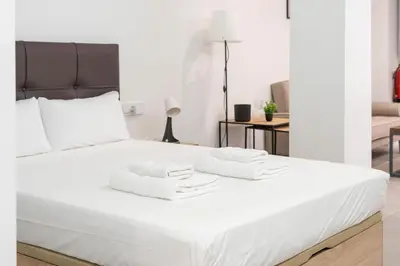 a white bed with two white towels on it at VLC HOST - Oriente in Valencia