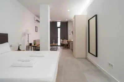a white room with a bed and a dining room at VLC HOST - Oriente in Valencia