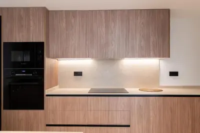 a kitchen with wooden cabinets and a black microwave at Aqua Suites Ciudad de las Artes I in Valencia